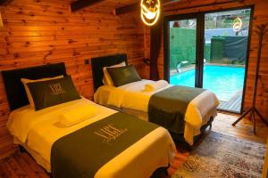 two beds in a room with a swimming pool at Vice Suit Bungalov in Sapanca