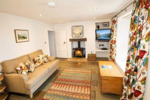 a living room with a couch and a fireplace at Red Squirrel Cottage, Hutton luxurious cottage in a rural setting 10 minutes to Ullswater 15 minutes to Keswick in Penruddock
