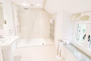 a white bathroom with a shower and a sink at Red Squirrel Cottage, Hutton luxurious cottage in a rural setting 10 minutes to Ullswater 15 minutes to Keswick in Penruddock +10 photos