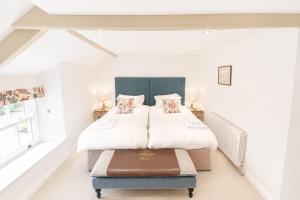 a bedroom with a bed and a ottoman in it at Red Squirrel Cottage, Hutton luxurious cottage in a rural setting 10 minutes to Ullswater 15 minutes to Keswick in Penruddock