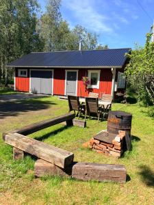 ein Haus mit einer Feuerstelle davor in der Unterkunft Verstas in Kustavi