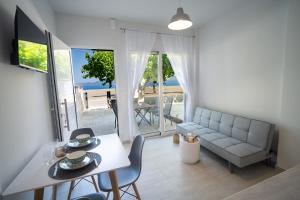 a living room with a couch and a table and chairs at Studios Kerasioti in Pefki