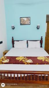 a bedroom with a bed with a wooden headboard at The Haira Varkala in Varkala