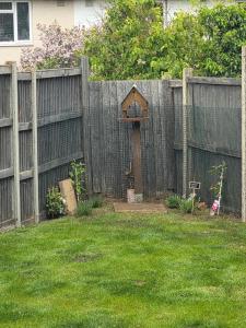 a wooden fence with a bird feeder in a yard at Olive & Ember - 1 Bed with private garden in Hythe