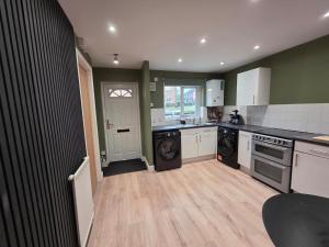 a kitchen with a washer and dryer in it at Olive & Ember - 1 Bed with private garden in Hythe