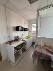a small kitchen with a sink and a table at Tamaly's Lodges in Basse-Terre