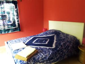 a bed with a blanket and two towels on it at Sanchaba Yellow Apartments in Kololi