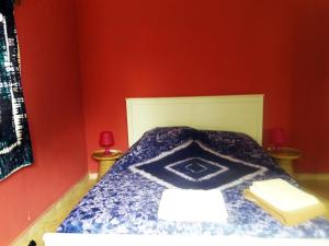 a bedroom with a blue bed with red walls at Sanchaba Yellow Apartments in Kololi