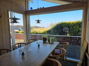 a dining room with a table and chairs and a large window at 30729-Odder-Alrovej-203-C in Odder