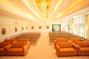 an empty hall with chairs and tables and a chandelier at Amorae Resort in Loni Khurd