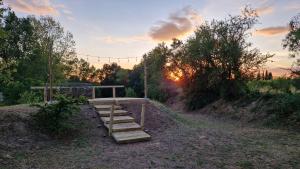 a wooden bench in a field with the sunset in the background at van domloc in Carcassonne