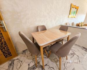 a wooden table and chairs in a room at Bab Fes Medina Appartements Familiaux 2 Chambres - Parking & Navette in Fez