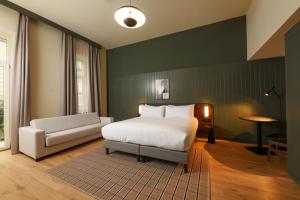 a bedroom with a white bed and a couch at Honest Budapest by chic&basic in Budapest