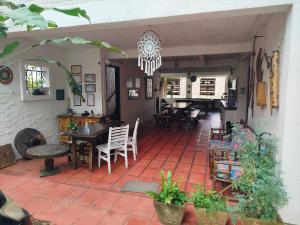 a patio with a table and chairs and a chandelier at Hostel Terra das Tribos in Ubatuba