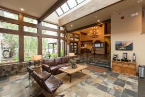 duży salon ze skórzanymi meblami i oknami w obiekcie Meadow Lake Resort & Condos w mieście Columbia Falls