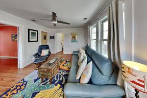 a living room with a couch and a table at CB Sunshine Cottage in Carolina Beach