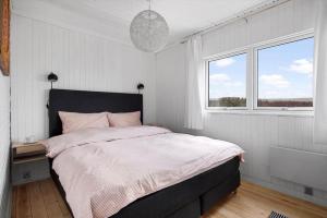 a bedroom with a large bed and two windows at 1671-Vejby-Blommevaenget-2 in Vejby