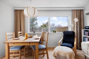 a dining room with a table and chairs and a window at 1671-Vejby-Blommevaenget-2 in Vejby +19 photos