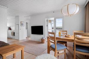 a living room with a dining table and a television at 1671-Vejby-Blommevaenget-2 in Vejby