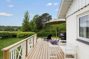a wooden deck with a table and an umbrella at 1671-Vejby-Blommevaenget-2 in Vejby