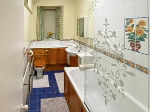 a bathroom with a tub and a sink and a toilet at Elizabeth Lodge - Cottage in Alford +7 photos