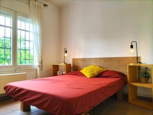a bedroom with a large bed with a red blanket at Casa Flor de Taronger in Viladecáns