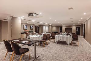 ein Esszimmer mit Tischen und Stühlen in einem Raum in der Unterkunft Radisson Blu Hotel, London South Kensington in London
