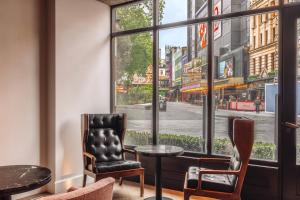 a room with two chairs and a table and a window at Radisson Blu Hotel, London Leicester Square in London +121 photos