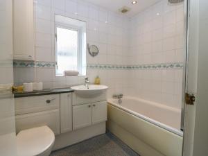 a bathroom with a sink and a tub and a toilet at Footdee Cottage in Aberdeen