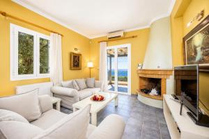 a living room with white furniture and a fireplace at Villa Penelope Sea View in Argostoli