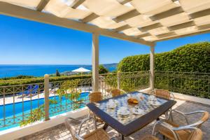 a table and chairs on a balcony with a view of the ocean at Villa Penelope Sea View in Argostoli