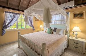 a bedroom with a bed with a canopy at Titi Vacation Homes in Cobbs Cross +53 photos