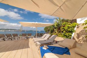a group of chairs and umbrellas on a beach at Sol Bahía Ibiza Suites in San Antonio