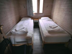 two beds in a small room with a window at Ásgarður Guesthouse in Hvolsvöllur