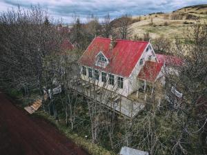 an old house with a red roof on a hill at Ásgarður Guesthouse in Hvolsvöllur