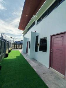 a house with a red door and green grass at ZK Loft Staycation Gensan in General Santos +3 photos