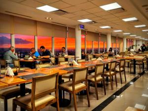 a group of people sitting at tables in a restaurant at WENELEN EXECUTIVE HOTEl in Añelo