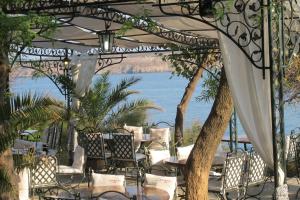 a patio with tables and chairs and a view of the ocean at Hotel Diamanti in Sozopol