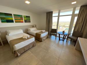 a hotel room with two beds and a table at WENELEN EXECUTIVE HOTEl in Añelo +40 photos