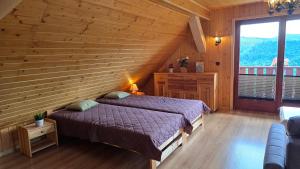a bedroom with a bed and a wooden wall at Szyszka & Igiełka in Rycerka Górna