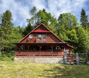 a large wooden cabin with a balcony on a hill at Szyszka & Igiełka in Rycerka Górna +43 photos