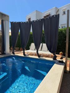 a swimming pool with blue water in front of a building at Villa Ferrera Select A in Cala Ferrera