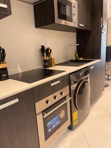 a kitchen with a stove and a dishwasher at Executive Suites at The Lennox in Accra