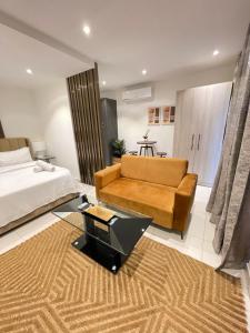 a bedroom with a bed and a couch and a television at Executive Suites at The Lennox in Accra +45 photos
