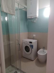 a bathroom with a washing machine and a toilet at Casa Morano in Schiavonea