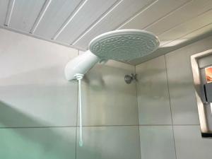a shower with a shower head hanging from a ceiling at Pousada Solar Maia Costa in Atins