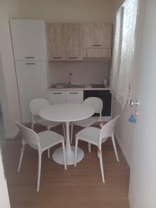 a small kitchen with a white table and chairs at Casa Morano in Schiavonea