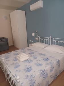 a bedroom with a bed with a blue and white blanket at Casa Morano in Schiavonea