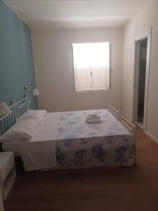 a bedroom with a bed with a blanket on it at Casa Morano in Schiavonea +3 photos