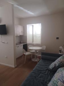 a living room with a bed and a table and a kitchen at Casa Morano in Schiavonea